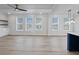 Bright, open living area with large windows, modern ceiling fan, and view into modern kitchen at 4190 Hosch Reserve Dr, Buford, GA 30519