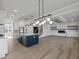 A kitchen and living room boasting an open floor plan, with hardwood floors and white paint, centered around an island at 4190 Hosch Reserve Dr, Buford, GA 30519