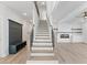 Bright staircase with wooden treads and modern railing, connects the home's floors, adjacent to a spacious living area at 4190 Hosch Reserve Dr, Buford, GA 30519