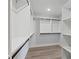Walk-in closet features custom shelving and racks with modern hardwood flooring at 4190 Hosch Reserve Dr, Buford, GA 30519