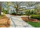 A stunning exterior view of a beautifully landscaped home with a long driveway and mature trees at 4635 High Point Rd, Atlanta, GA 30342