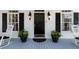 Welcoming front entrance with a black door, black shutters, and potted plants on a blue painted porch at 4635 High Point Rd, Atlanta, GA 30342