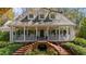 Inviting two-story home with a large front porch, brick stairs and lush landscaping at 4635 High Point Rd, Atlanta, GA 30342