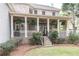 Back porch with brick columns, black railings, hanging ferns and fan at 570 Glengate Cv, Atlanta, GA 30328