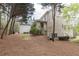 Exterior backyard view of a brick home with a porch, tall trees, and wood mulch at 570 Glengate Cv, Atlanta, GA 30328