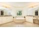 Bright and luxurious bathroom with a soaking tub, granite counters, and double vanities for comfort and style at 570 Glengate Cv, Atlanta, GA 30328