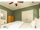 Cozy bedroom with olive green walls, a ceiling fan, a large bed, and access to an ensuite bathroom at 570 Glengate Cv, Atlanta, GA 30328