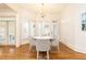 Bright dining room features a round table, seating for four, a modern chandelier, and hardwood floors at 570 Glengate Cv, Atlanta, GA 30328
