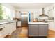 Bright kitchen features stainless appliances, grey kitchen island with marble countertop, and white cabinets at 570 Glengate Cv, Atlanta, GA 30328