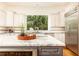Bright kitchen features stainless appliances, a grey kitchen island with a marble countertop, and white cabinets at 570 Glengate Cv, Atlanta, GA 30328