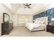 Inviting main bedroom with tray ceiling, large window, and accent wall for added charm and style at 570 Glengate Cv, Atlanta, GA 30328