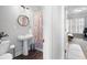 Cozy bathroom with a colorful shower curtain, a stylish mirror, and a pedestal sink leading to bedroom at 706 Registry Run, Kennesaw, GA 30152