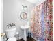 Cozy bathroom with a colorful shower curtain, a stylish mirror, and a pedestal sink at 706 Registry Run, Kennesaw, GA 30152