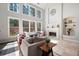 Sunlit living room with high ceilings, a fireplace, and large windows overlooking a wooded area at 706 Registry Run, Kennesaw, GA 30152