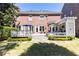 Spacious backyard featuring lush grass, a brick house and an entertainment area with seating at 825 Glengate Pl, Atlanta, GA 30328