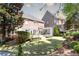Spacious backyard featuring lush green lawn, landscaping, patio, and backing up to another brick house at 825 Glengate Pl, Atlanta, GA 30328