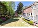 Serene backyard with patio, lush lawn, colorful flowers, and mature trees create a peaceful retreat at 825 Glengate Pl, Atlanta, GA 30328