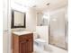 Well-lit bathroom featuring a vanity with decorative mirror, granite countertop, and glass door shower at 825 Glengate Pl, Atlanta, GA 30328
