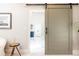 Bathroom doorway with sliding barn door leading to a spacious and well-lit bathroom with luxurious details at 825 Glengate Pl, Atlanta, GA 30328