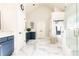 Modern bathroom featuring marble floors, blue vanity, glass shower, and high ceilings, offering a spa-like experience at 825 Glengate Pl, Atlanta, GA 30328