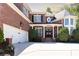 Impressive brick home featuring a white garage, gabled roof, and well-manicured landscaping at 825 Glengate Pl, Atlanta, GA 30328