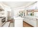 Bright white kitchen featuring stainless steel appliances, an island, and hardwood floors at 825 Glengate Pl, Atlanta, GA 30328