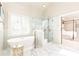 A luxury bathroom featuring a soaking tub, glass shower, and marble tile at 825 Glengate Pl, Atlanta, GA 30328