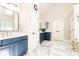Bathroom with dual sinks, blue cabinets, marble floor and adjacent soaking tub at 825 Glengate Pl, Atlanta, GA 30328