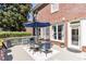 Outdoor patio featuring dining set with blue umbrella, complementing the brick facade of the house at 825 Glengate Pl, Atlanta, GA 30328
