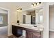 Bathroom featuring a double vanity with dark wood cabinets and a large framed mirror at 1301 Odell Ct, Hoschton, GA 30548