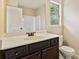 Bathroom with a dark wood vanity, framed mirror and ample counter space at 1301 Odell Ct, Hoschton, GA 30548