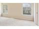 Bedroom with neutral walls and carpet, featuring two windows for natural light at 1301 Odell Ct, Hoschton, GA 30548