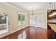 Dining area features a window, hardwood floors, and an exterior door for access to the back at 1301 Odell Ct, Hoschton, GA 30548