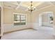 Bright dining room with a chandelier, decorative wall trim, neutral carpet, and large windows at 1301 Odell Ct, Hoschton, GA 30548