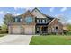 Inviting two-story home featuring a brick facade, manicured lawn, and a spacious three-car garage at 1301 Odell Ct, Hoschton, GA 30548