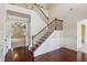 Elegant foyer with hardwood floors, staircase with iron spindles, and arched doorways leading to other rooms at 1301 Odell Ct, Hoschton, GA 30548
