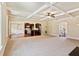 Bright open-concept living area featuring coffered ceilings, large windows, and seamless flow to the kitchen at 1301 Odell Ct, Hoschton, GA 30548