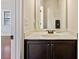 A modern powder room features a pedestal sink with contemporary fixtures and dark cabinetry at 1301 Odell Ct, Hoschton, GA 30548