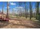 The home has a large backyard with tall trees, a stream, and new-growth grass at 181 Bridgewood Se Dr, Conyers, GA 30094