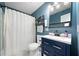 Charming bathroom boasts a blue vanity and a shower with curtain at 181 Bridgewood Se Dr, Conyers, GA 30094