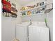 Well-organized laundry room with storage shelves above a side-by-side washer and dryer at 181 Bridgewood Se Dr, Conyers, GA 30094