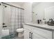 Cozy bathroom features tub shower with tiled backsplash, granite top vanity and sink at 396 Academy St, Alpharetta, GA 30009