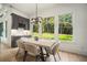 A dining room with a large window showcasing private backyard views, wood floors, and a stylish light fixture at 396 Academy St, Alpharetta, GA 30009
