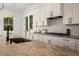 Bright kitchen showcasing white cabinets, stone countertops, stainless gas range, undermount sink, and a garden view at 396 Academy St, Alpharetta, GA 30009