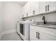 Bright laundry room featuring white cabinets, granite countertops, and modern washer and dryer at 396 Academy St, Alpharetta, GA 30009