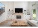 Bright living room showcases a stone fireplace, custom built-ins, and large windows for natural light at 396 Academy St, Alpharetta, GA 30009