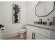 Modern powder room with elegant octagon mirror, black fixtures, and white cabinets at 396 Academy St, Alpharetta, GA 30009
