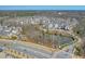 Overhead view of a large community with various styles of townhomes near a tree lined street and small pond at 6601 Cadence Blvd, Atlanta, GA 30328
