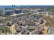 An aerial view of a neighborhood featuring townhomes, surrounded by trees and city buildings in the background at 6601 Cadence Blvd, Atlanta, GA 30328