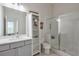 Well-lit bathroom featuring a glass shower, white vanity, and ample storage space at 6601 Cadence Blvd, Atlanta, GA 30328
